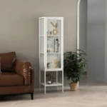 ויטרינת מתכת לבנה עם דלת זכוכית דגם 210, עומדת בסלון לצד ספה מעור חום ומראה קשתית