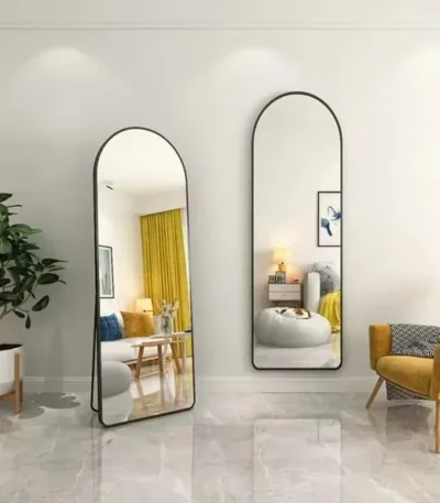שתי מראות גוף בצורת קשת עם מסגרת מתכת שחורה, אחת עומדת ואחת תלויה על קיר, בסלון עם וילון צהוב - הדמיית חדר