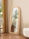 תקריב על מסגרת מראת הגוף בצורת קשת מרופדת בבד קטיפה בגוון בז'-חול