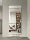 מראת גוף מלבנית לבנה דגם 9005 - מותקנת על קיר בז' מול סלון עם כוננית מוארת